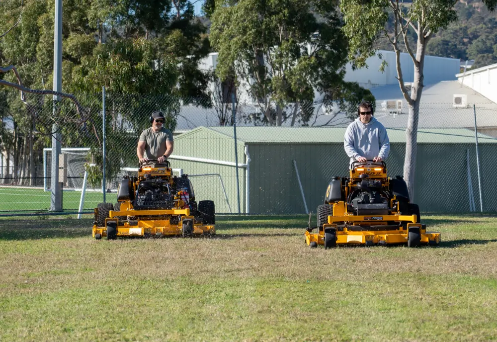 Eco-friendly electric mower in action during professional grass cutting service by Greencut Mowing
