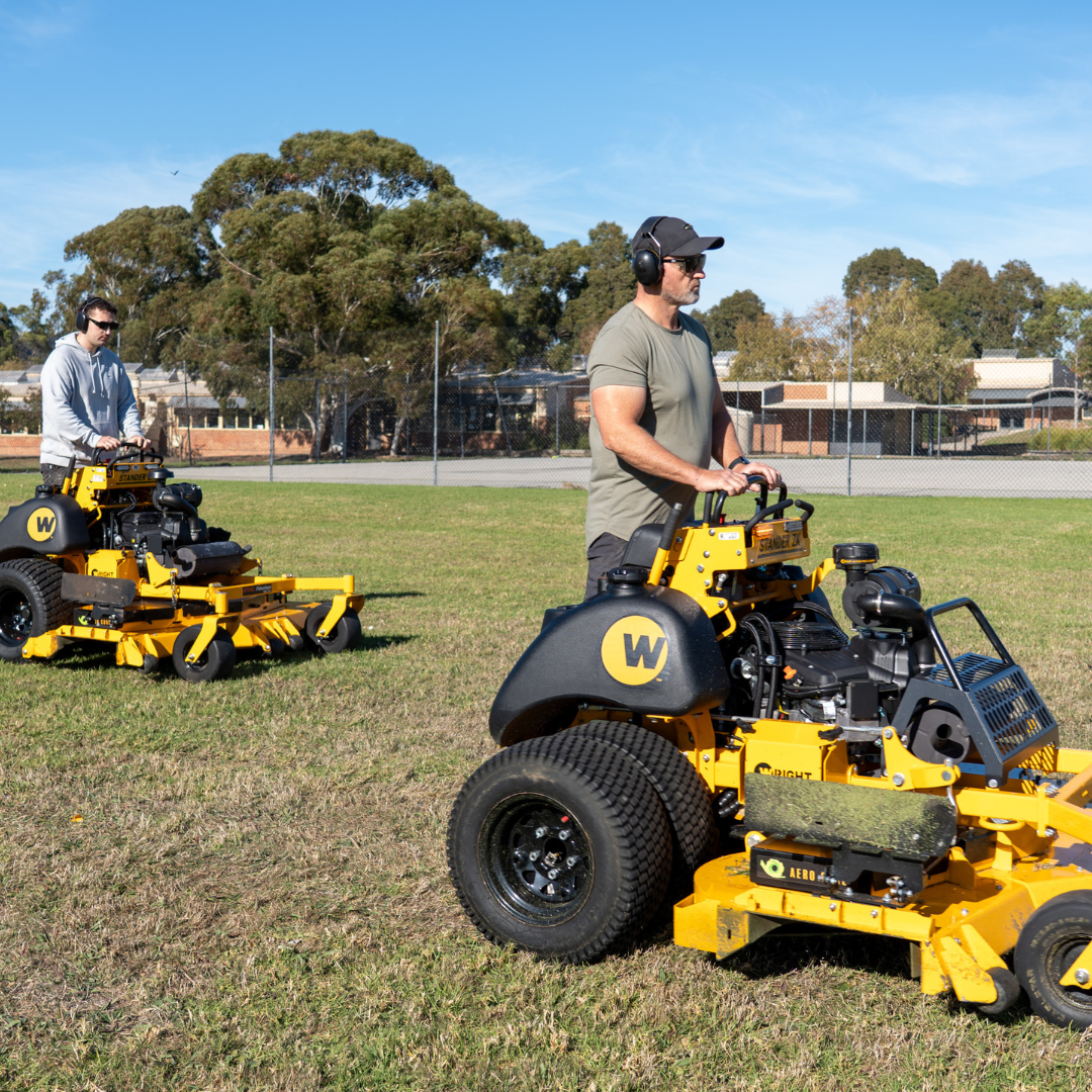 Grounds crew mowing and maintaining lawns on a school campus in Melbourne.